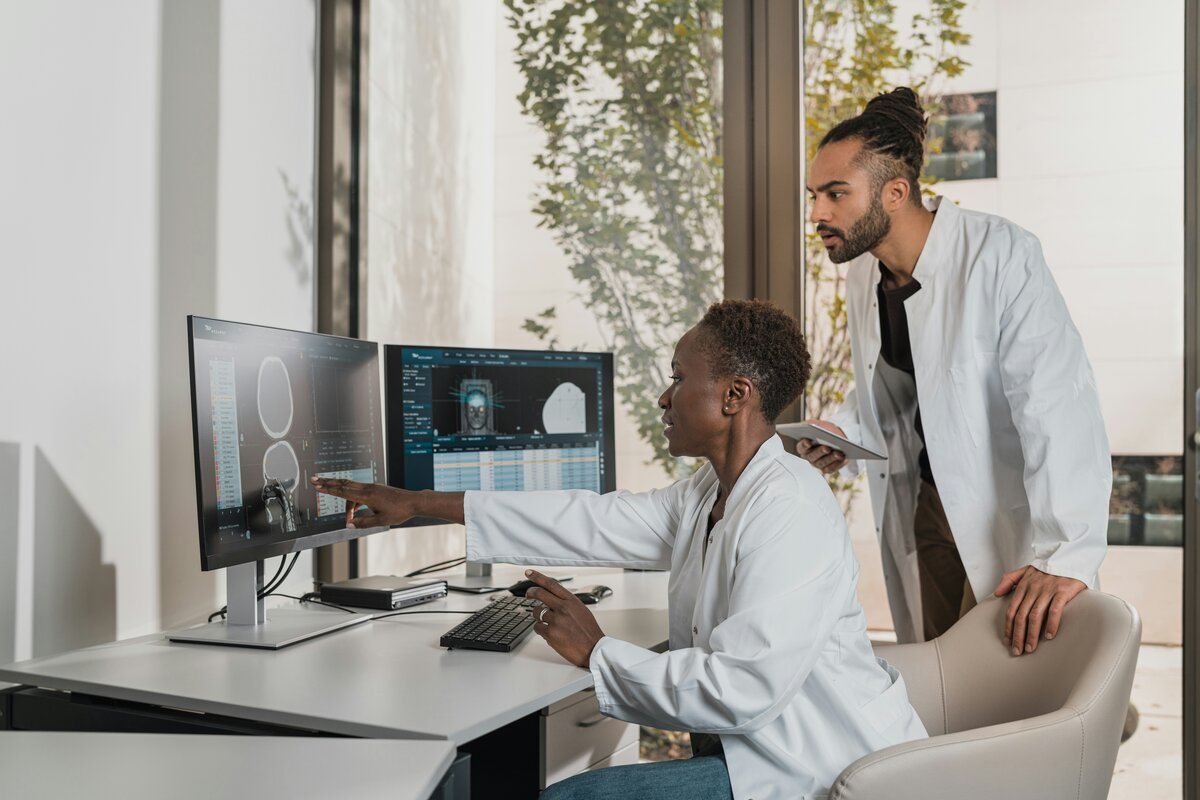 Two researchers reviewing neuroimaging data at a workstation